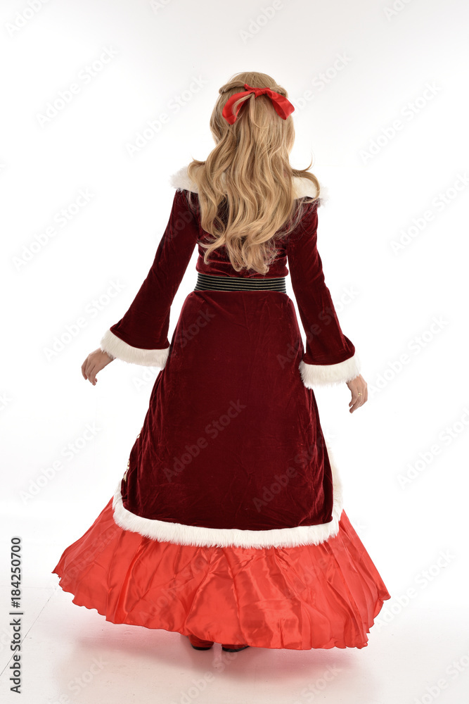 full length portrait of pretty blonde lady wearing red and white christmas inspired costume gown, standing pose on white background. full length portrait of pretty blonde lady wearing red and white christmas inspired costume gown, standing pose on white background.