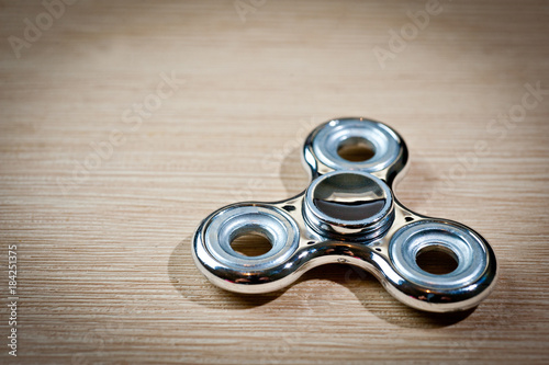 Brilliant, metal spinner on a wooden surface