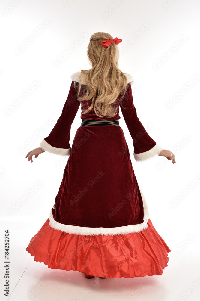 full length portrait of pretty blonde lady wearing red and white christmas inspired costume gown, standing pose on white background. full length portrait of pretty blonde lady wearing red and white christmas inspired costume gown, standing pose on white background.