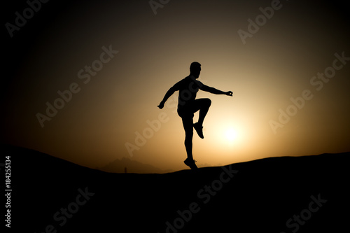 Athlete with muscular body in dusk