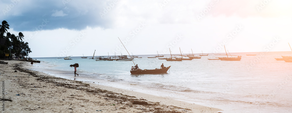 panoramic view of seashore with fishermen and fishing boats in the sea