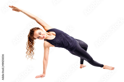 Young fit woman doing pilates excercises isolated on white background