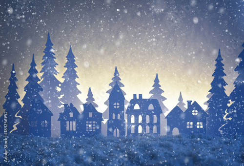 Paper winter landscape with village and Christmas trees in snow night.