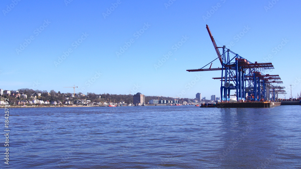 HAMBURG, GERMANY - MARCH 8th, 2014: View on the Burchardkai of the Hamburg harbor. Container ship TABEA is unloaded and loaded during a clear blue sky day