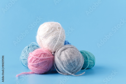 Leisure hobby concept, clew of natural wool on blue background