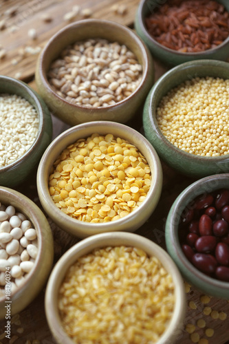 Bowls of various cereals in small containers on a wooden background, Cereal Mix, Beans, sesame, rice, pearl barley, wheat, Closeup, Selective focus