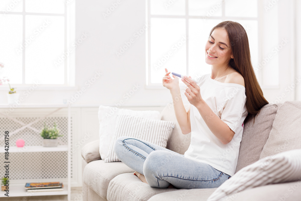 Happy girl with pregnancy test at home Happy girl with pregnancy test at home