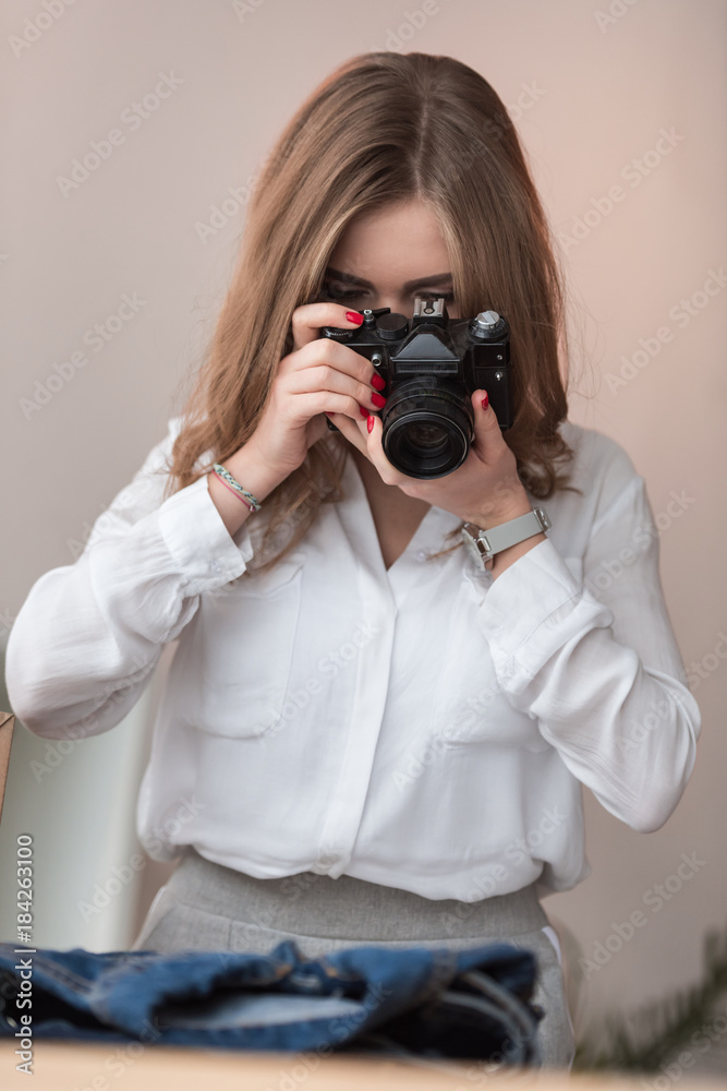 obscured view of self-employed businesswoman taking picture of products for customers at home office obscured view of self-employed businesswoman taking picture of products for customers at home office