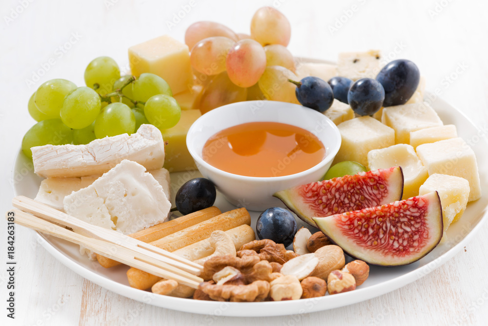 plate of cheese, fruit and snacks, closeup plate of cheese, fruit and snacks, closeup