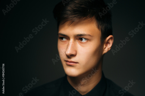 Portrait young guy on a dark studio