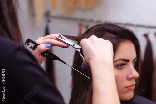 the girl is cut the split ends of hair in the hairdresser's