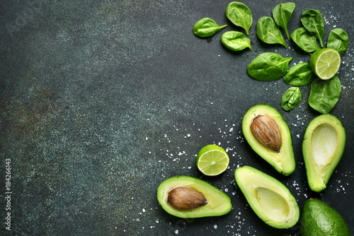 Food background with green vegetables : avocado,baby spinach and lime.Top view with space for text.