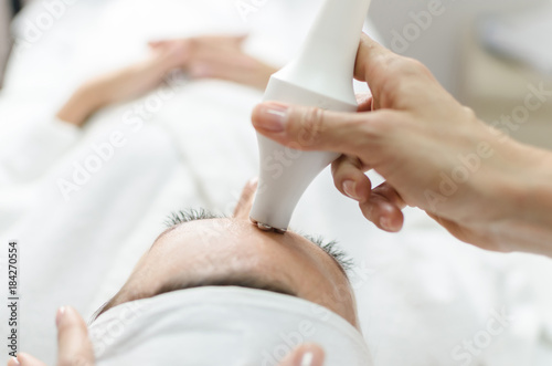 Woman during laser and ultrasound face treatment.