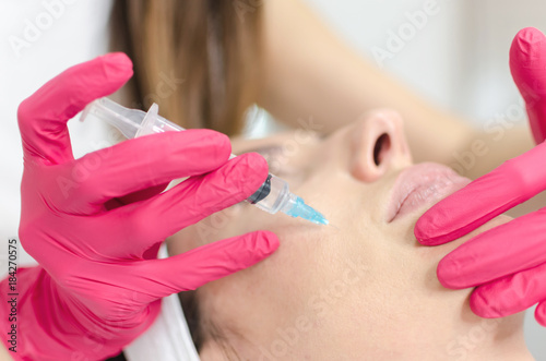 Woman during injection for rejuvenation in face