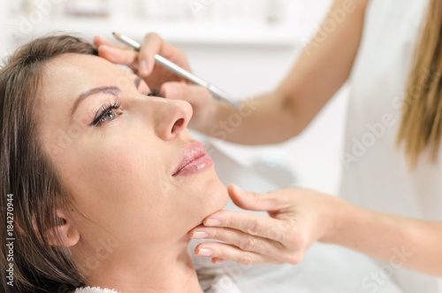 Woman in beauty salon on examination face skin