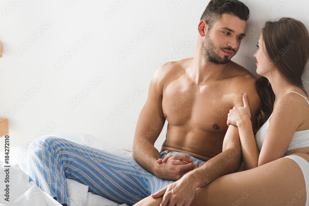 young couple sitting in bed in morning and holding hands young couple sitting in bed in morning and holding hands