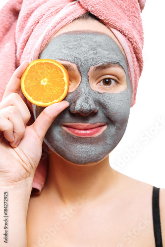 mask for skin woman, happy and funny girl makes a mask for face skin, girl closes her eyes with orange, girl is smiling, isolated photo