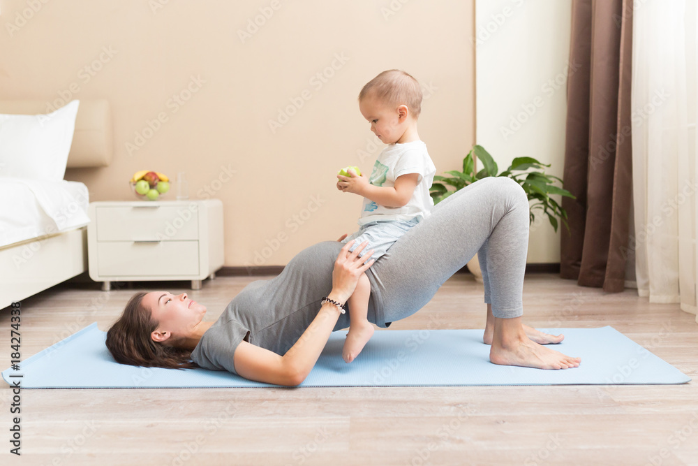 Belichamen Circulaire Uitbreiden Sportive beautiful pregnant mother with baby son exercising on blue yoga mat.  Athletic and healthy motherhood. Fitness, happy maternity and healthy  lifestyle concept. Stock Photo | Adobe Stock