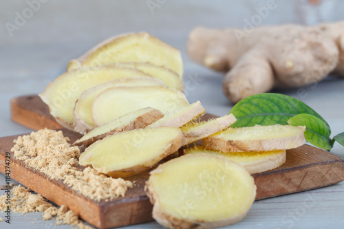 Ginger root - Fresh ginger root and sliced on wooden board