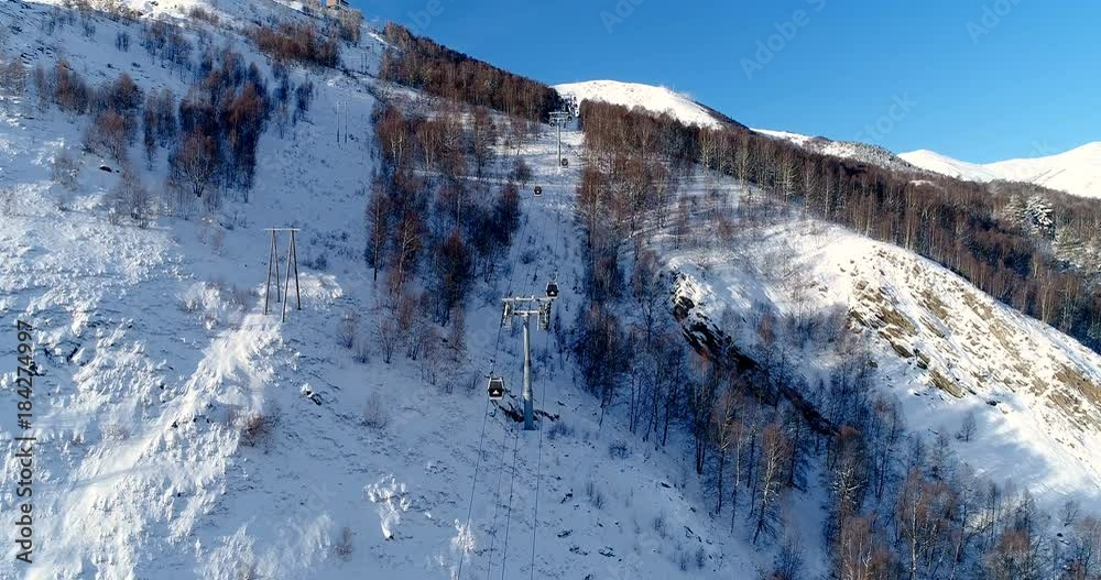 Vue magnifique au dessus d'un télésiège dans la forêt - vue aérienne avec un drone - neige rocher câble siège monter descendre montagne France skieur arbre vacances tourisme voyage sport ski ciel bleu