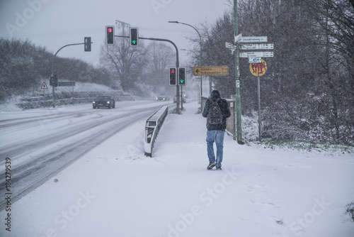 a man walking on a road in heavy snow , Germany, Hesse 2017