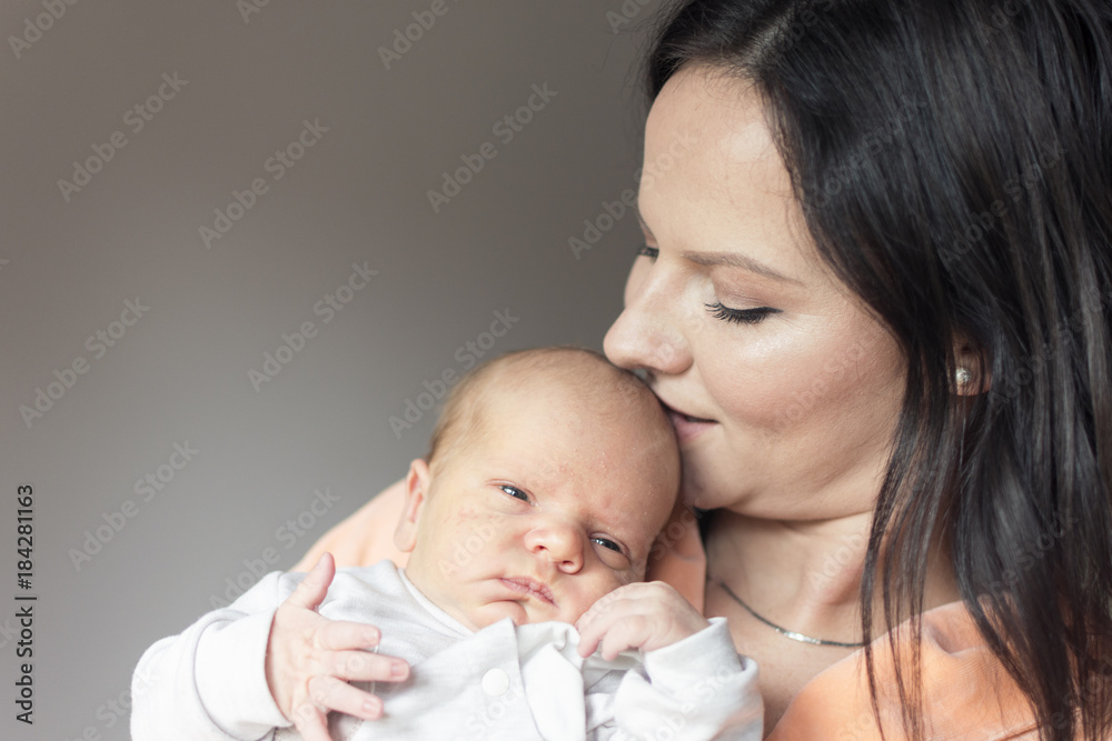 preety woman in her arms is holding and loving her newly born child preety woman in her arms is holding and loving her newly born child