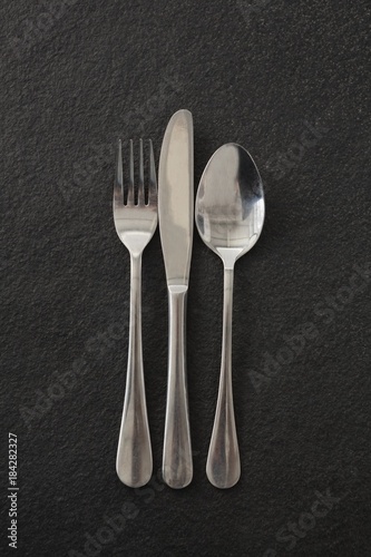 Fork, spoon and knife on black background