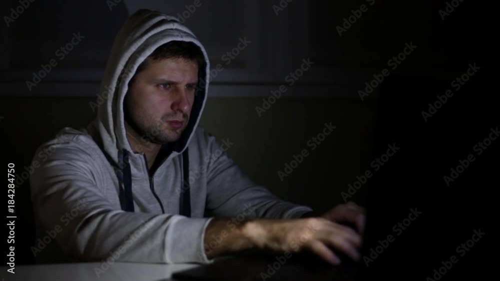 A male hacker with a laptop. A male hacker with a laptop.