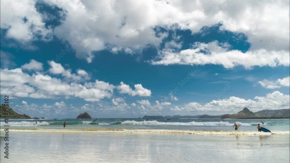 Timelapse Clouds over the Pantai Selong Belanak Beach with lots of surfers beginners at the Lombok island, Indonesia