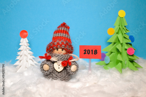 A little smiling girl (doll) at a New Year's tree, Happy New Year Card 2018