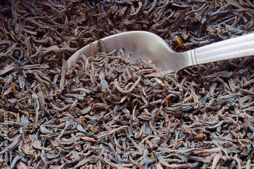 dry tea in a metal spoon. close up