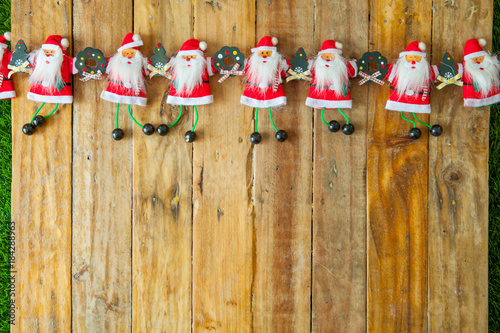 Christmas background with santa claus doll holding hands on wooden table background with a copy space