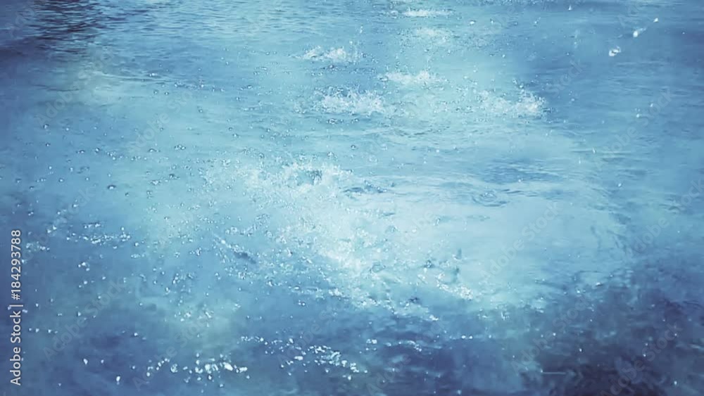 slow motion of heavy rain water drops or foutain on surface street, seamless loop ready