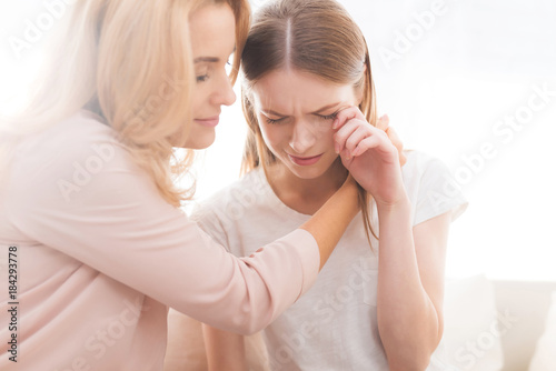 A woman comforts a teenage daughter.