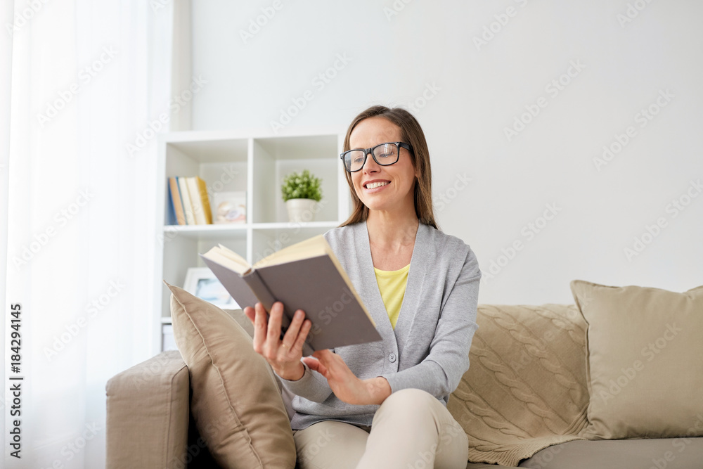 happy woman in glasses reading book at home happy woman in glasses reading book at home