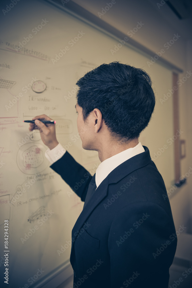 Asian businessman write plan on board,Thailand people write something on white board Asian businessman write plan on board,Thailand people write something on white board