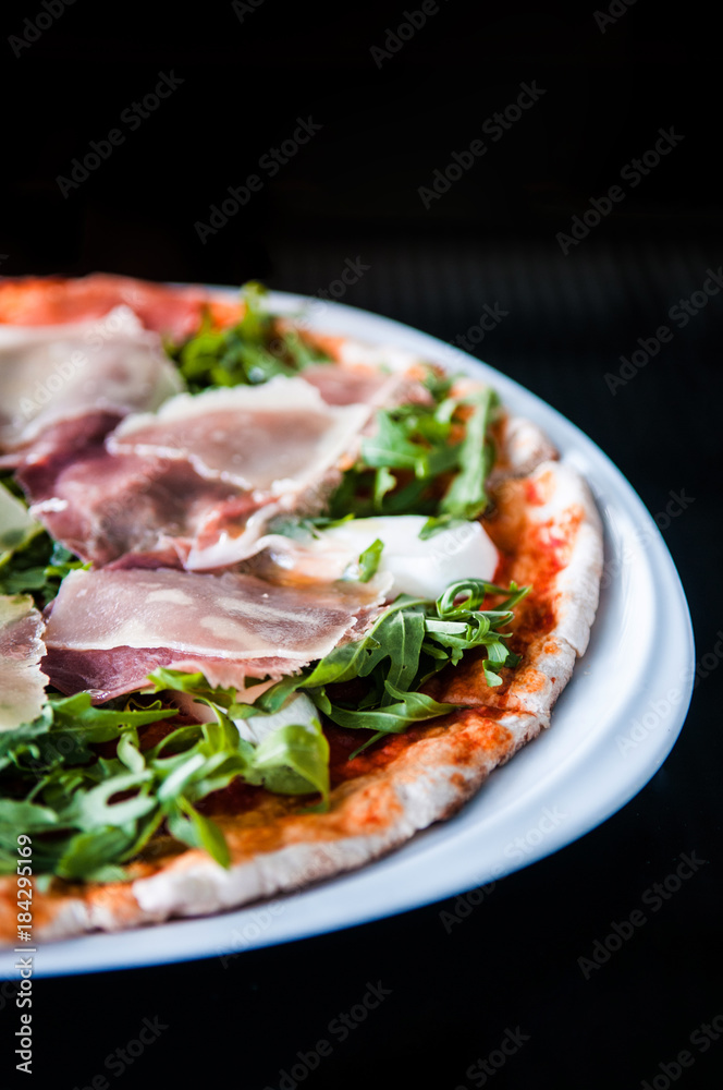 Italian pizza slice pamaham arugula and margarita sauce in vertical shot Italian pizza slice pamaham arugula and margarita sauce in vertical shot