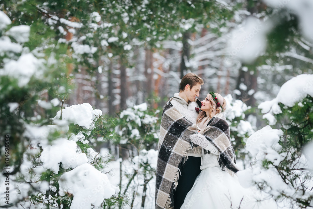 Romatic couple in love the plaid looks at each other in winter forest. Artwork. Wedding Romatic couple in love the plaid looks at each other in winter forest. Artwork. Wedding