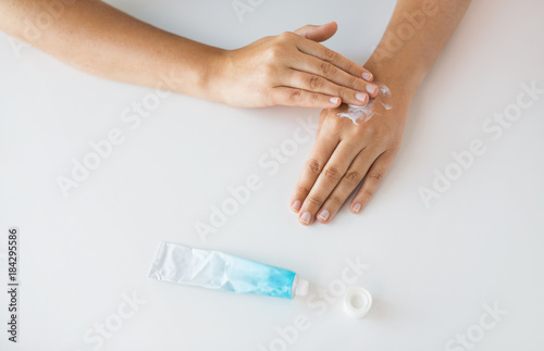 close up of hands with cream or therapeutic salve