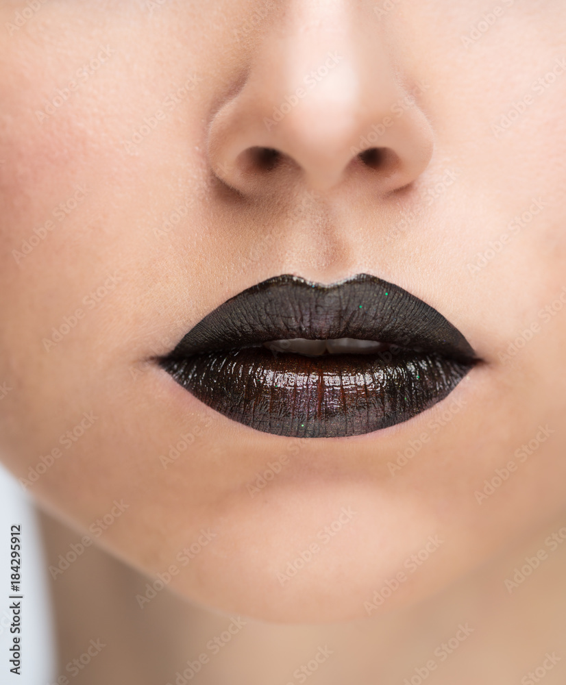 Fototapeta premium Lips painted with black lipstick