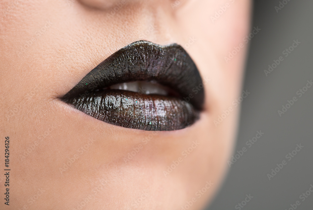 Naklejka premium Lips painted with black lipstick
