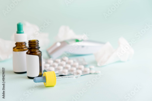 flu treatments. Spray for the nose or a pill to treat colds and gripes. Glass Bottle with medicines and paper handkerchiefs on blue background. Copy space for text. mockup, Top view. flat lay. photo