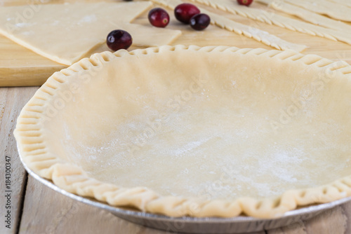 Baking pan with dough prepared for homemade crandberry pie. photo