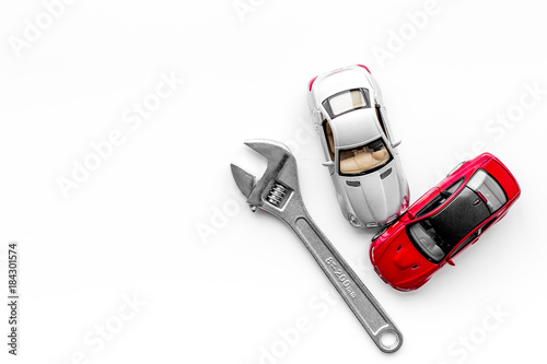 Car repair concept. Wrench near car toys on white background top view copyspace