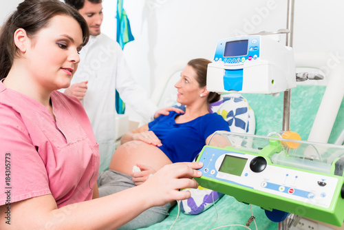 Pregnant woman, doctor and nurse in labor room photo