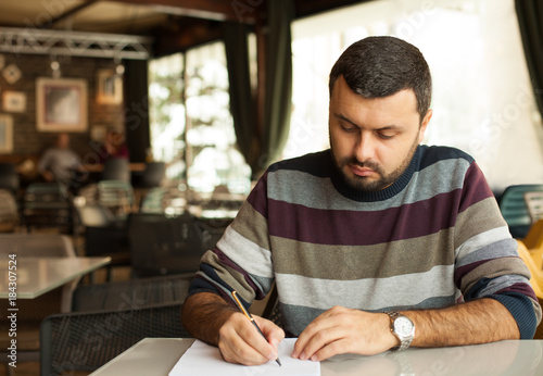Handsome man writing a letter