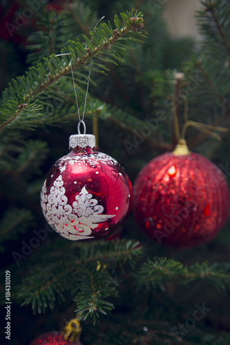 Red baubles made of glass on a fir tree