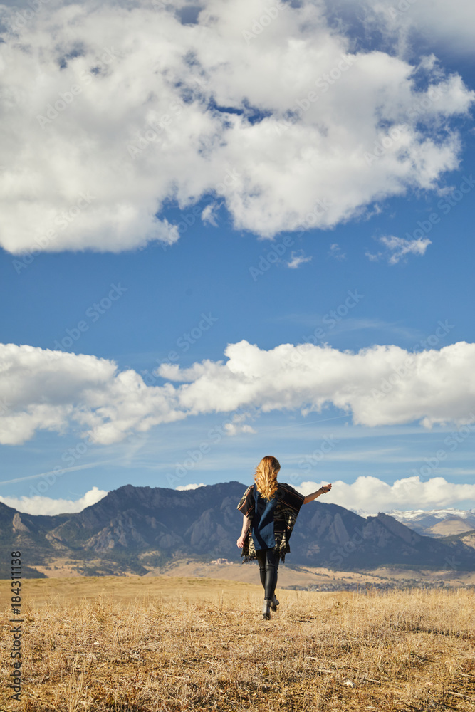 Women walking through field with mountain view
