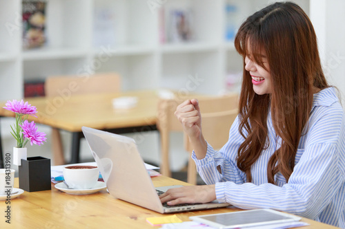 Beautiful Asian business girl concept cheerful celebrate working at coffee shop connected on laptop computer celebrate, success or happy pose.