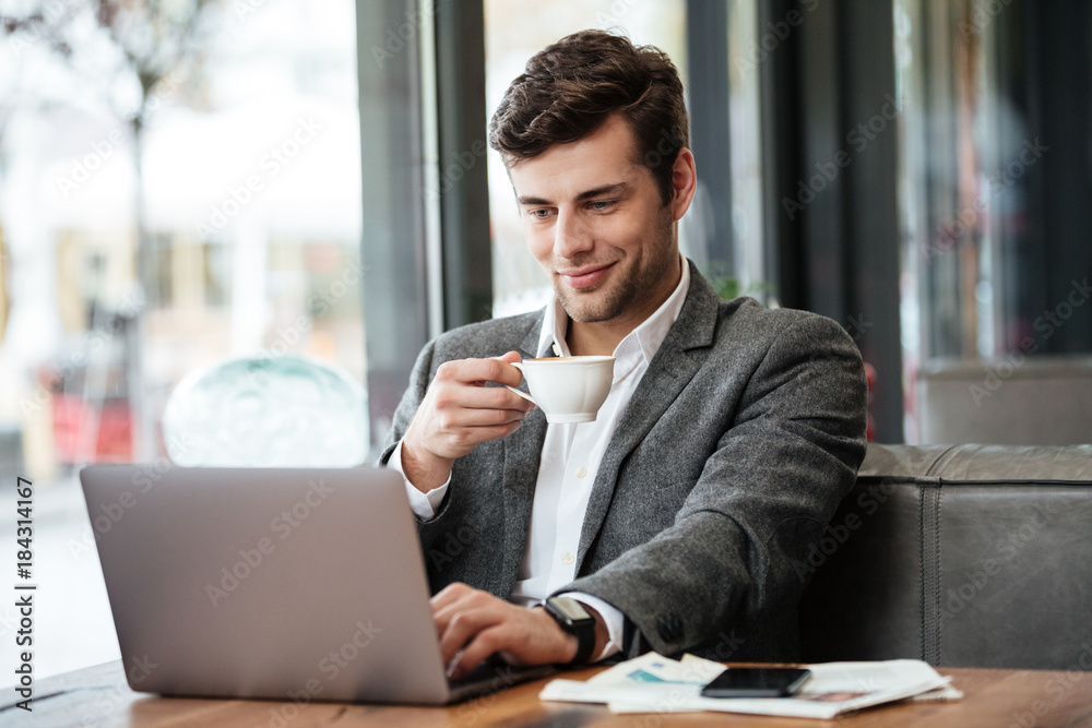 Smiling business man sitting by the table in cafe Smiling business man sitting by the table in cafe
